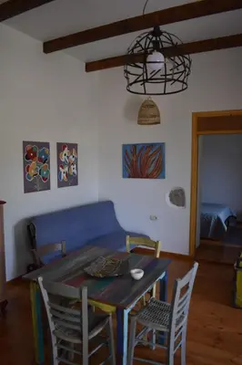 a dining room table with chairs and a blue couch at Telesilla's home in Apothíkai