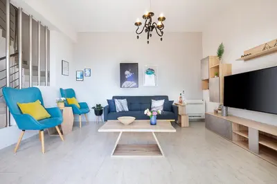 a living room with a blue couch and a tv at Villa Narciso in Souda