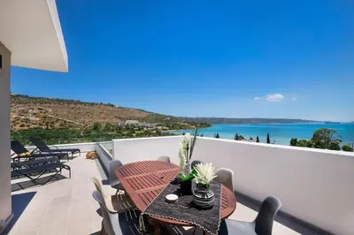 a balcony with a table and a view of the ocean at Villa Narciso in Souda