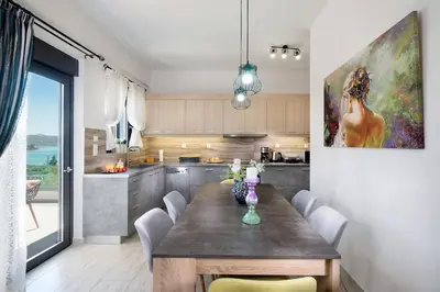 a kitchen with a table and a painting on the wall at Villa Narciso in Souda
