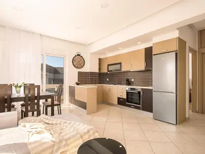 a kitchen and dining room with a table and a refrigerator at Chania sea view apartment - Crete in Galatás