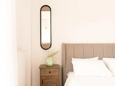 a bedroom with a bed and a mirror on the wall at Chania sea view apartment - Crete in Galatás