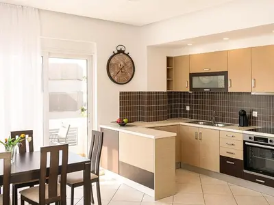 a kitchen with a table and a clock on the wall at Chania sea view apartment - Crete in Galatás
