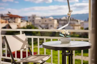 a table and a chair on a balcony with a view at Theni City Apartment by Zen Estate in Chania Town