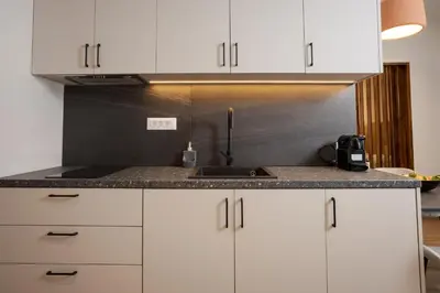 a kitchen with white cabinets and a sink at Theni City Apartment by Zen Estate in Chania Town