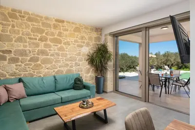 a living room with a blue couch and a table at Mythelea Luxury Villa in Kissamos