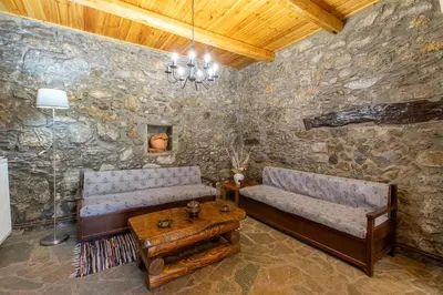 a living room with two couches and a table at Vavouledo Village House in Khamalévri