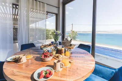 a table with food on it with a view of the ocean at Villa Orama - Sea view with private pool in Kalyves