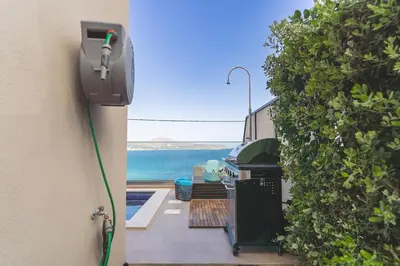 a view of a backyard with a grill and the ocean at Villa Orama - Sea view with private pool in Kalyves