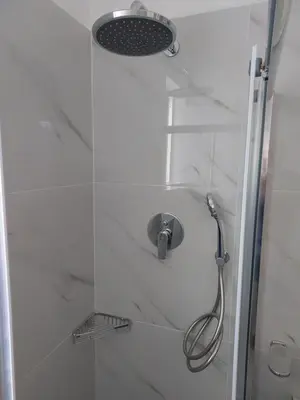 a shower with a shower head in a bathroom at Beachfront apartment in Daratso