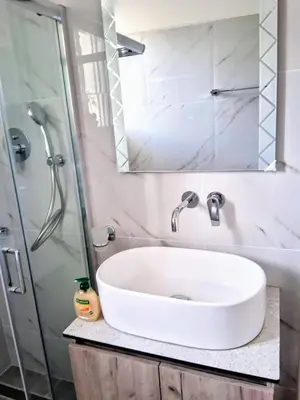 a bathroom with a white sink and a shower at Beachfront apartment in Daratso