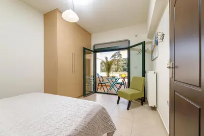 a bedroom with a bed and a chair and a patio at Lucia's Home in Stalos