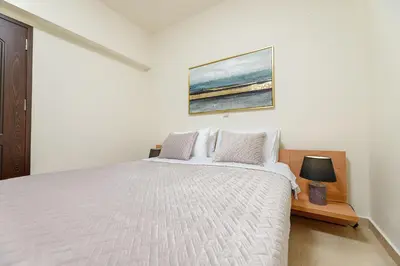 a bedroom with a white bed and a painting on the wall at Lucia's Home in Stalos
