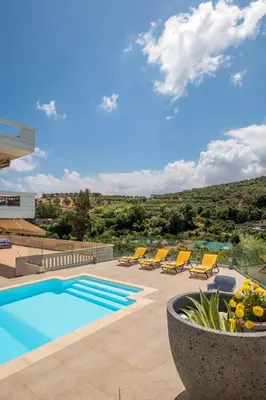 a swimming pool with lounge chairs and a pool at Lucia's Home in Stalos