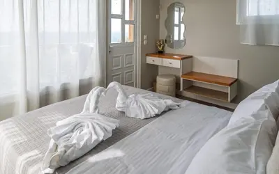 a white bed with white sheets and a window at View West Elafonisi house in Livadia