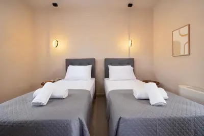 two beds with white pillows on them in a room at Villa George in Límni