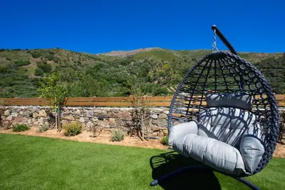 a swing in a yard with a rock wall at Villa George in Límni