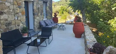a patio with chairs and a table and a building at Petra Homes Temenia in Teménia