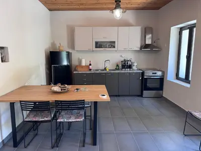 a small kitchen with a wooden table and chairs at Petra Homes Temenia in Teménia