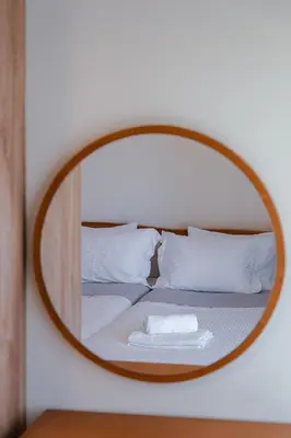 a mirror on top of a bed with white pillows at Villa Avelios in Karefilianá
