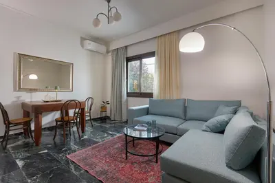 a living room with a couch and a table at Katsambas Apartment - Cozy Retro-Luxury with Balcony in Chania Town