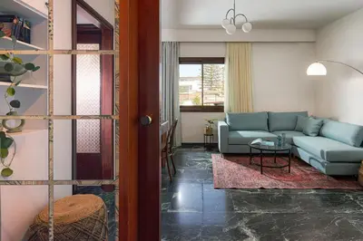 a living room with a couch and a table at Katsambas Apartment - Cozy Retro-Luxury with Balcony in Chania Town