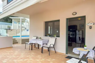 a patio with a table and chairs and a kitchen at Casa Barbara in Stalos