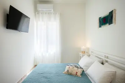 a bedroom with a bed with a television on the wall at Bella Apartment in Chania Town