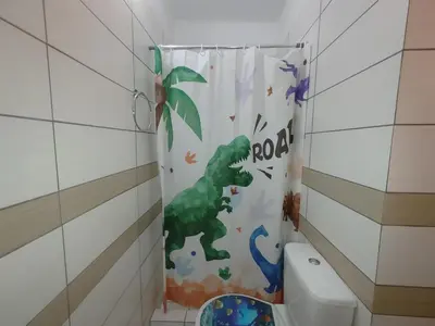a shower curtain with a dinosaur on it in a bathroom at Lumen Chania in Chania Town