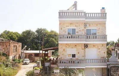a large brick house with a large balcony on it at Tzei House - 5min drive to beach in Perivólia