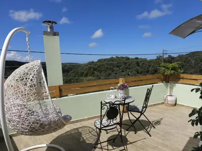 a patio with a hammock and a table and chairs at Elaida Home in Psathoyiánnos