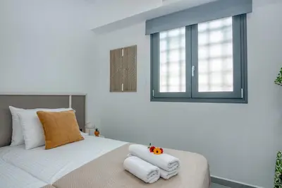 a bedroom with a bed with towels on it at Gems - Stunning 2BR Apts - Steps from the Beach! in Kissamos