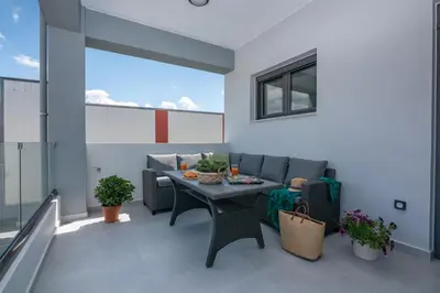 a living room with a table and a couch at Gems - Stunning 2BR Apts - Steps from the Beach! in Kissamos