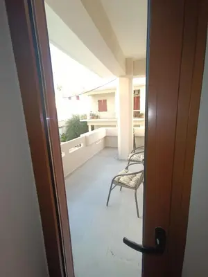 an open door to a balcony with a chair at Saxon's Corner in Chania Town