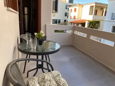a small table and chairs on a balcony at Saxon's Corner in Chania Town