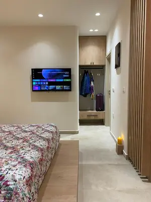 a bedroom with a bed and a tv on the wall at Saxon's Corner in Chania Town
