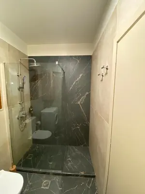 a bathroom with a glass shower and a toilet at Saxon's Corner in Chania Town