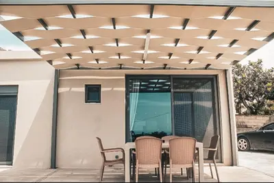 a patio with a table and chairs under a ceiling at Luxury apartment Reverie in Sfakiá