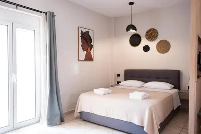 a white bedroom with a bed and a window at Nektaria Studio in Chania Town