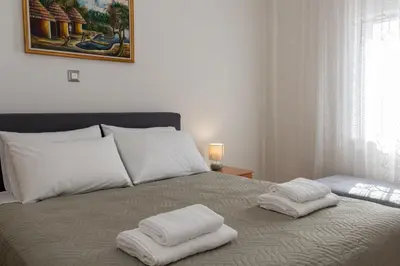 a bed with two white towels on top of it at Lumea Apartment in Chania Town