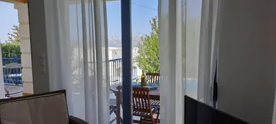 a room with a balcony with a table and a window at Villa Agassi Aspo Apokoronas Crete in Koprána