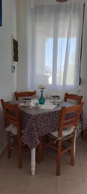 a dining room table with chairs and a table and a window at Villa Agassi Aspo Apokoronas Crete in Koprána