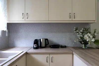 a kitchen with white cabinets and a vase of flowers at Chania Garden Retreat in Souda