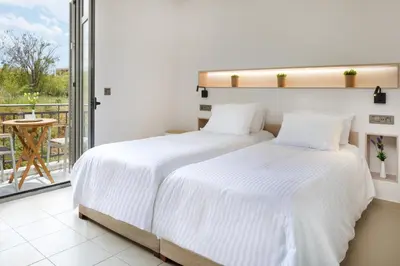two beds in a bedroom with a balcony at Forum City Apartments in Chania Town