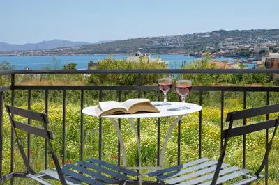 a table with two glasses of wine and a book at Forum City Apartments in Chania Town