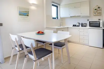a white kitchen with a white table and chairs at Forum City Apartments in Chania Town