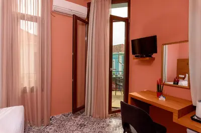 a hotel room with a bed and a desk and a mirror at TheJoy in Chania Town