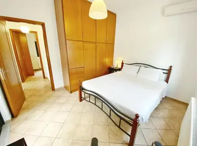 a bedroom with a white bed and a hallway at Green door in Nerokoúros