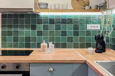 a kitchen with green tiles on the wall at Central old Town house with jacuzzi and yard,4ppl in Chania Town