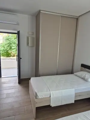 a bedroom with a bed and a sliding glass door at Aldea Apartments in Palio Gerani